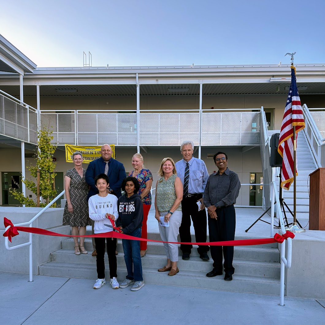 students and adults cutting ribbon on new facility